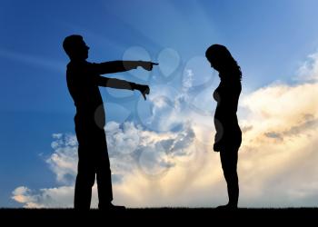 A silhouette of a man showing a finger at a woman telling her that she is a loser. The concept of social problems, humiliation of women