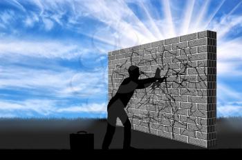 A silhouette of a businessman breaks the wall with your hands . The concept of overcoming challenges in business