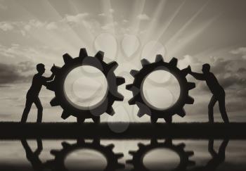 Silhouette of two people who want to connect the two gears in a single mechanism. The concept of cooperation in business