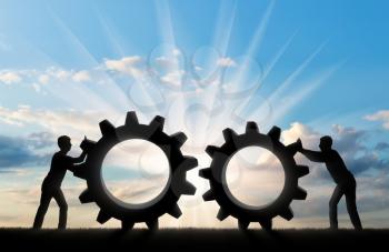 Silhouette of two people who want to connect the two gears in a single mechanism. The business partnership concept