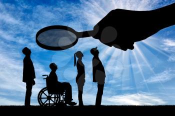 Eagnifying glass in the hand of a man gazes intently at a disabled person in a wheelchair. The concept of social problems