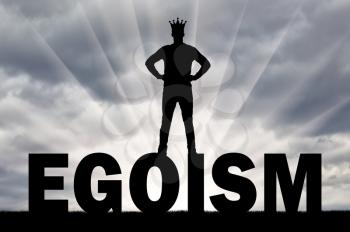 Silhouette of a man with a crown on his head is on the word ego. Concept of selfishness