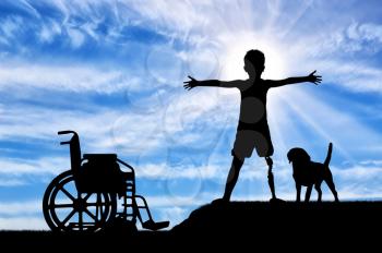 Children with disabilities concept. Happy disabled boy with a prosthetic leg standing near a wheelchair and his friend dog