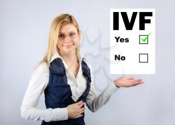 IVF. A woman holds a questionnaire where they chose in vitro fertilization. Conceptual image of in vitro fertilization