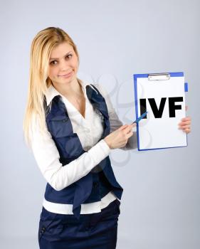 IVF. A woman shows on her tablet the abbreviation in vitro fertilization. Conceptual image of in vitro fertilization