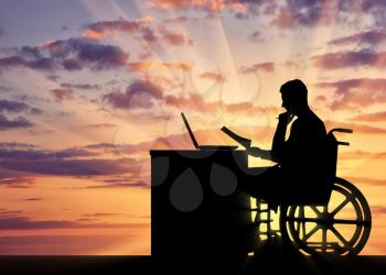 Silhouette of a man a businessman disabled in a wheelchair sitting at a table. The concept of working disabled people