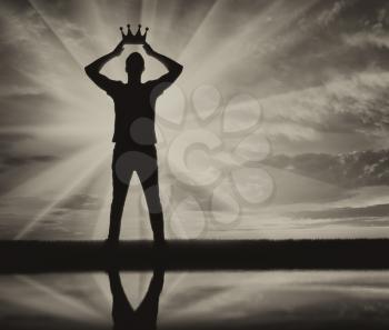 Concept of narcissism and selfishness. Silhouette of a selfish and narcissistic man reconciling his own crown