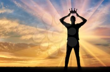Concept of narcissism and selfishness. Silhouette of a selfish and narcissistic man reconciling his own crown