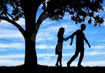 The concept of divorce and parting of a married couple. Silhouette of a man throwing a woman near a tree
