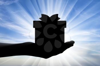 Altruism concept. Silhouette of a hand giving a gift