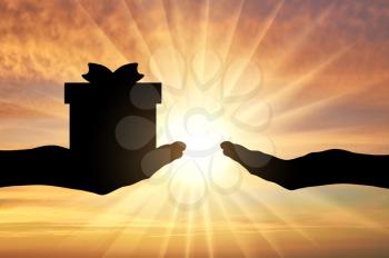 Altruism concept. Silhouette of a hand giving a gift and a hand receiving a gift on a sunset background