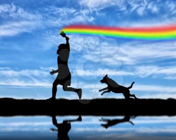 Childhood concept. The child with brush in hand runs and draws a rainbow in sky with his dog