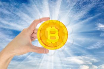 Bitcoin in hand against the sky. The concept of crypto currency
