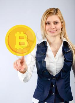 The woman presses the bitcoin icon with her finger. The concept of crypto currency