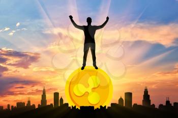 Happy man standing on a coin Ripple against the background of the city. The concept of success in the crypto currency