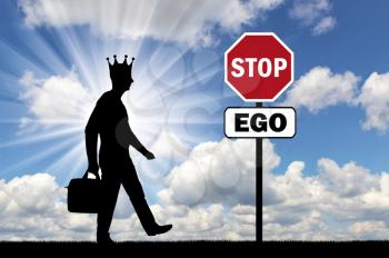 Silhouette of a selfish man with a crown on his head and a road sign of a stop ego. The conceptual scene of selfishness as a problem of society