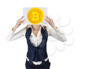 A woman holds a sheet of paper where a bitcoin coin is depicted on the head level. The concept of crypto currency