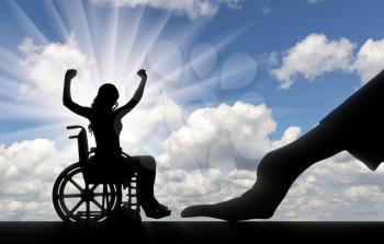 Disabled worker. Silhouette of a big hand of an employer hires a happy disabled woman in a wheelchair