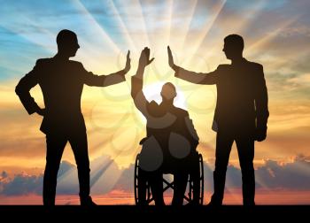 Disabled worker. Silhouette of a disabled man in a wheelchair and two workers make a hand gesture, give five on sunset background