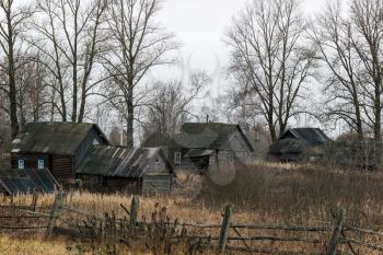 Sad cloudy landscape with abandoned houses in the village Paltsevo. Russia, Tver region, Bologovsky District.