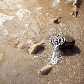 Key in the river sand. Photo toned.