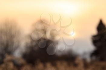 Defocused background with autumn sunset in warm colors.