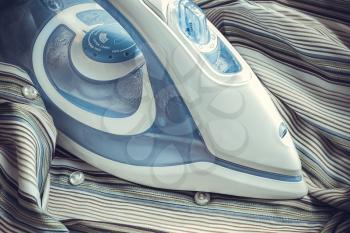 Ironing beautiful modern iron. Photo tinted in shades of blue.