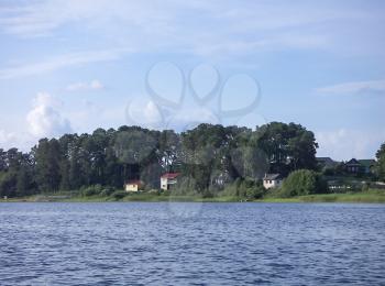Lake landscape with houses and pine forests