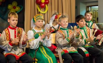 The children's ensemble in folk costumes playing on wooden spoons. Russia.