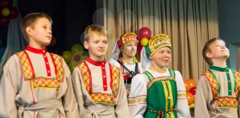 The children's ensemble in folk costumes. Focus on the girl banide in the second row. The contest-festival of children's artistic creativity - of the Master and the children. Russia, the city of Udoml