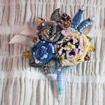 Textile brooch with embroidered flowers decorated with beads and pearls. handiwork.