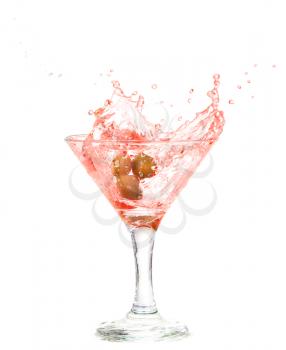 Splash from olive in a glass of cocktail, isolated on the white background, clipping path included.
