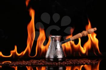 Turk on coffee beans on a background of fire, black background. CONCEPT vivacity and energy