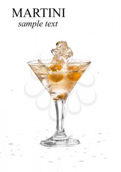A martini glass on a white background; the water ripples and splashed as a green spanish olive with pimento is dropped into the glass; horizontal format (with sample text)