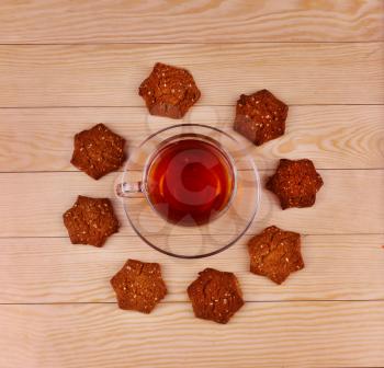 Cup of tea and cookies on wooden background top view