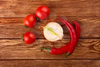 Red hot cherry and chili peppers over white wooden background onion 