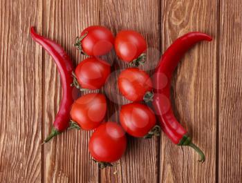 Red hot cherry and chili peppers over white wooden background