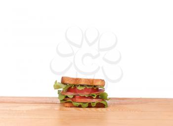 big sandwich with fresh vegetables on wooden board on white background