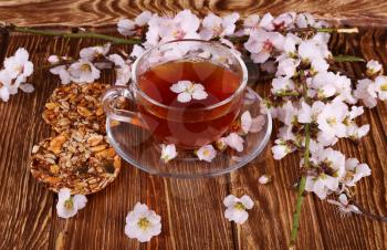 tea and a branch of cherry blossoms on a wooden