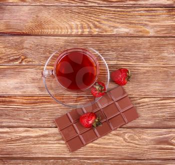 A cup of tea or coffee. Dark Chocolate. Wooden background.