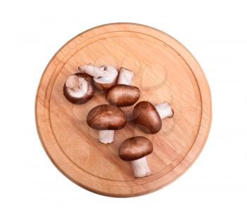 Raw mushrooms on the cutting board over white background
