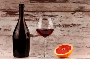 Red wine bottle on a wooden background, apple and pomegranate