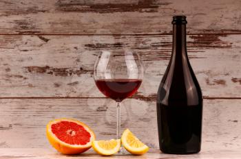 Red wine bottle on a wooden background, apple and pomegranate