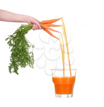 Juice pouring into glass of young carrots. which keeps women's hands isolated on white