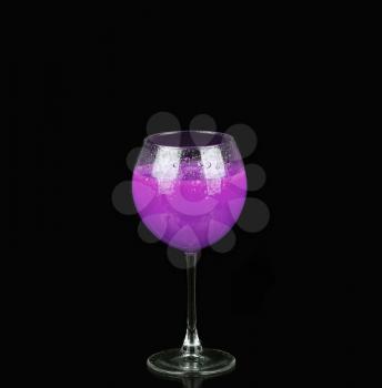 Purple alcoholic cocktail in a glass on black