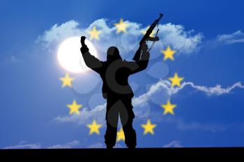 Silhouette of military soldier or officer with weapons at sunset. shot, holding gun, colorful sky, Concept of a terrorist. Silhouette terrorists with rifle, national flag on background - European Unio