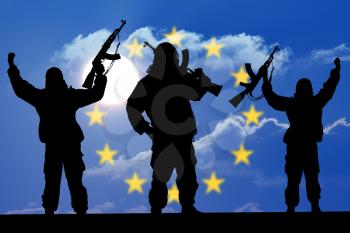 Silhouette of military soldier or officer with weapons at sunset. shot, holding gun, colorful sky, Concept of a terrorist. Silhouette terrorists with rifle, national flag on background - European Unio