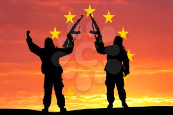 Silhouette of military soldier, shot, holding gun, colorful sky, Concept of a terrorist. Silhouette terrorists with rifle, national flag on background - European Union - EU