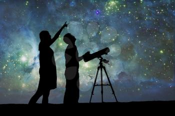 Silhouette of Telescope. Elements of this image furnished by NASA. The boy and girl are watching the night sky. Love under the stars