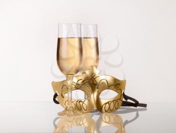 two glass with champagne on a table with Masquerade mask 